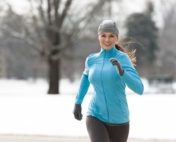 femme pratiquant la course  pied dans le froid sur un chemin couvert de neige
