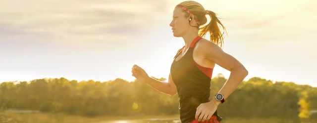 Femme pratiquant la course  pied en coutant de la musique avec une montre