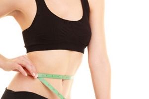 thin woman measuring her waist
